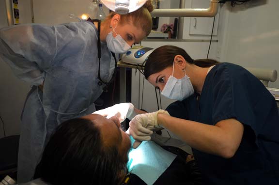 Dr. Ann Marie Maggio, attending dentist, checks resident Dr. Ashley Orth’s patient.
