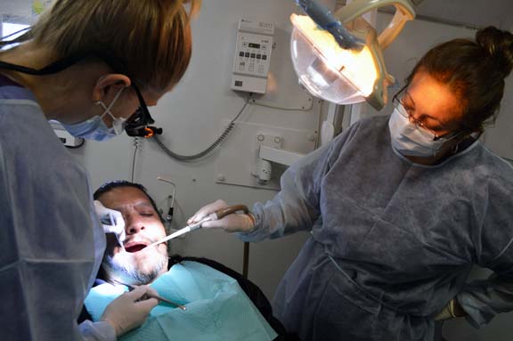 Dr. Ashley Orth, dental resident, and Nohora Hernandez, dental assistant examine Jose Rodriguez, Jr.
