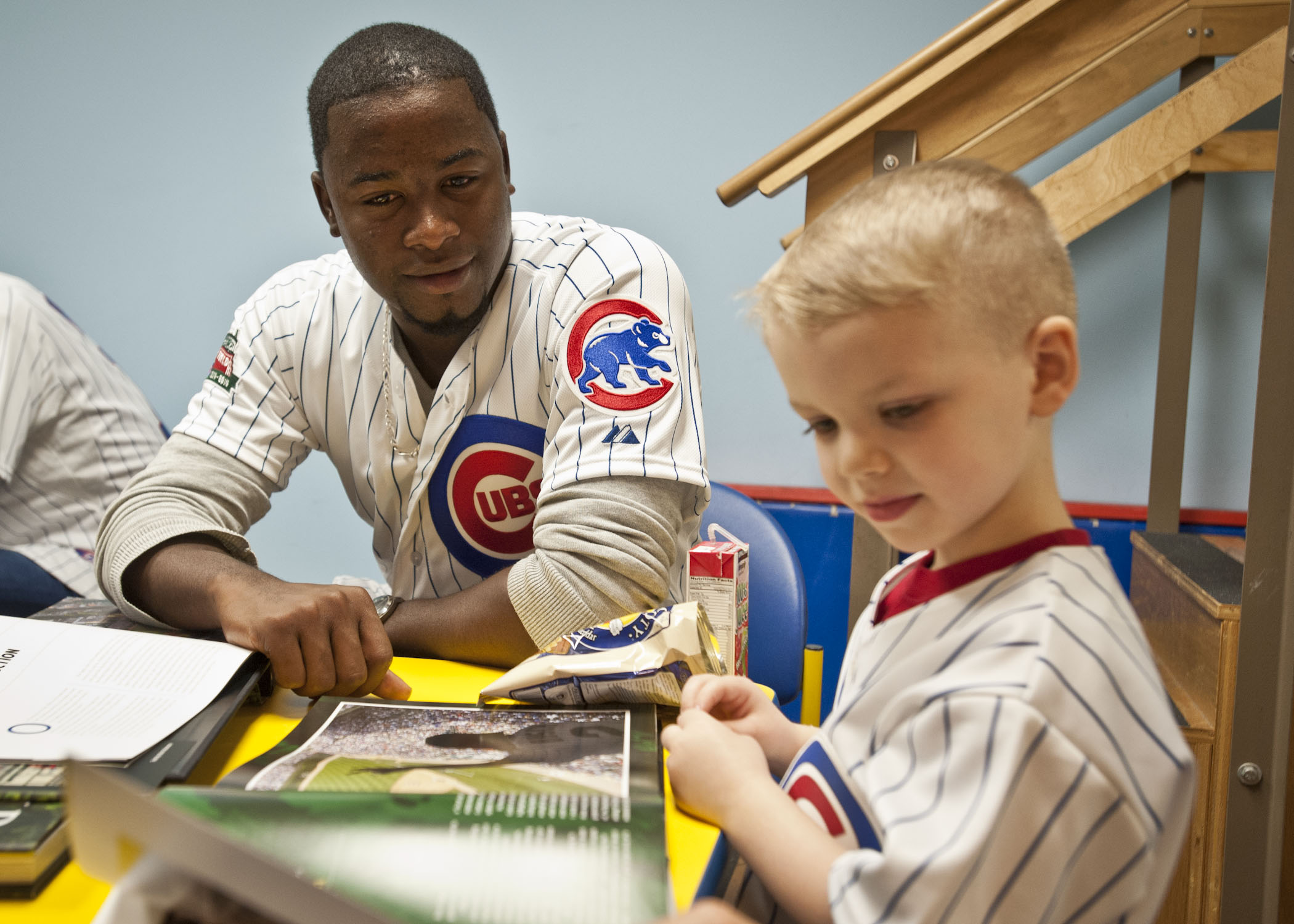 Cubs prospect Arodys Vizcaino looks through a Wrigley Field book with this little guy.