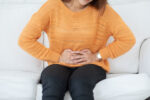 A woman has stomach pain from abdominal pain.