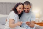 A couple looking at a positive pregnancy test after the woman had signs of pregnancy.