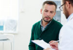 A man discussing prostate cancer screening with his doctor.