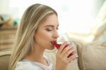 Woman drinking cranberry juice.