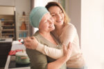 A person with cancer is comforted by a friend.