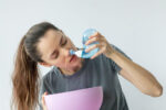 A woman uses a neti pot to relieve her nasal congestion.