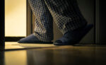 Adult man in pijamas walks to a bathroom at the night. Men's healths concept