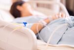 A woman in a hospital bed recovering from septic shock after infection.