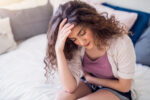 A woman experiencing premenstrual syndrome (PMS) during her menstrual cycle.