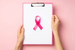 A clipboard with a pink breast cancer ribbon on top to indicate breast cancer results.