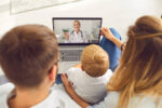 Parents and their child on a virtual telehealth doctor's visit.