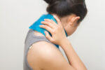 Woman using ice pack or cold therapy for neck pain.