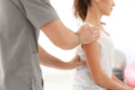 A chiropractor helps treat a woman's back pain.