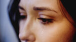 A woman crying tears from her eyes.