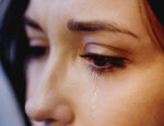 A woman crying tears from her eyes.