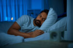 A man lying awake at night with insomnia.