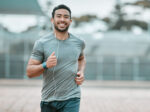 A runner running outside while smiling.