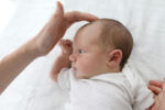 Baby turning head to side possibly caused by neck condition.