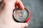 A person opening a can of soda.