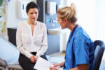 A woman patient discusses her breast cancer risk with doctor.