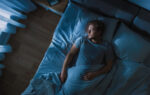 A man sleeping in bed experiencing sleep paralysis.