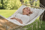 A woman is tired from the warm, sunny day.