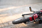 A bike on ground after bicycling accident. Photo encouraging riders to follow the bike safety tip of wearing a bike helmet.