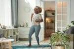 A woman dancing at her house as a cardio alternative to running.