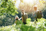 A family hiking on a wooded trail, possibly getting tick bites.