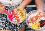 A couple eating acai bowls to be healthy.