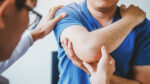 A man getting his elbow injury, tennis elbow, checked out by a doctor.
