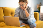 A woman signing up for a health insurance plan on her laptop.