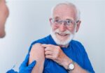 An older adult is getting his recommended vaccines.