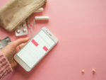 A woman using a cycle synching phone app to track her menstrual cycle.