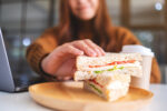 A woman eating a carb containing sandwich on a diet.