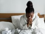 A woman sick with respiratory illness in bed during the winter.