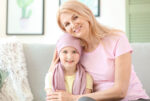 A childhood cancer patient with her caregiver.