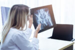 A doctor explains anterior hip replacement with the help of an x-ray.