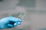 A health care provider getting ready to give a patient both the flu and COVID vaccines.