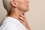 A woman touches suspicious thyroid nodule.