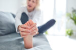 A woman has foot pain.