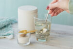 A woman mixing collagen supplements into water for its benefits.