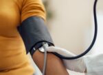 A woman getting a blood pressure reading at doctor's office.