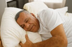 A man sleeping peacefully after taking a GLP-1 to treat obesity and therefore sleep apnea.