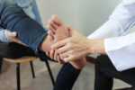 A doctor examines the feet of a person with diabetes for health concerns.