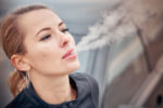 A woman smoking a cigarette which decreases life expectancy.
