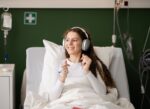 A female hospital patient listening to music before or after surgery to improve outcomes.