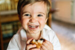 A young child eating sugary food, leading to high sugar intake.