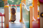 A child at the playground, which can lead to injury if not supervised.