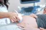 A pregnant woman receiving an ultrasound of her in-utero baby with congenital heart disease.