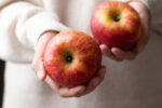 A woman holding apples, a healthy fall fruit.